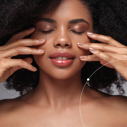 Woman with hands on her face against a neutral background